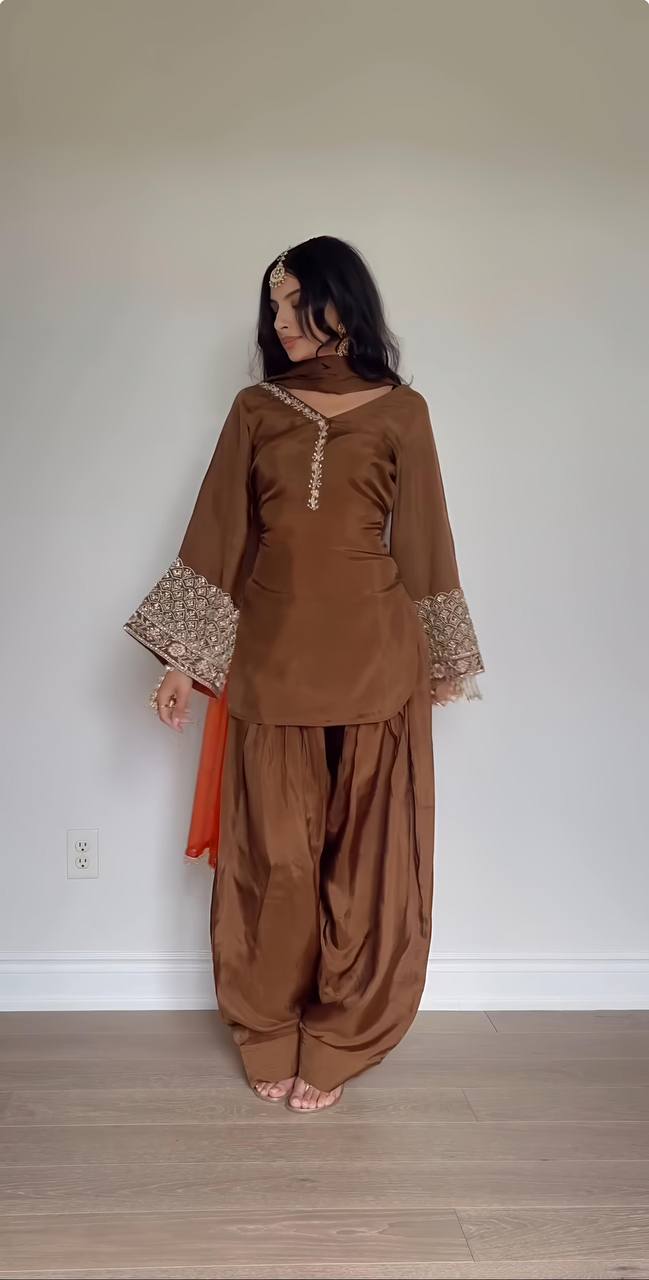 Elegant Brown Traditional Outfit with Orange Dupatta, Embellished Sleeves, and Gold Jewelry Ensemble